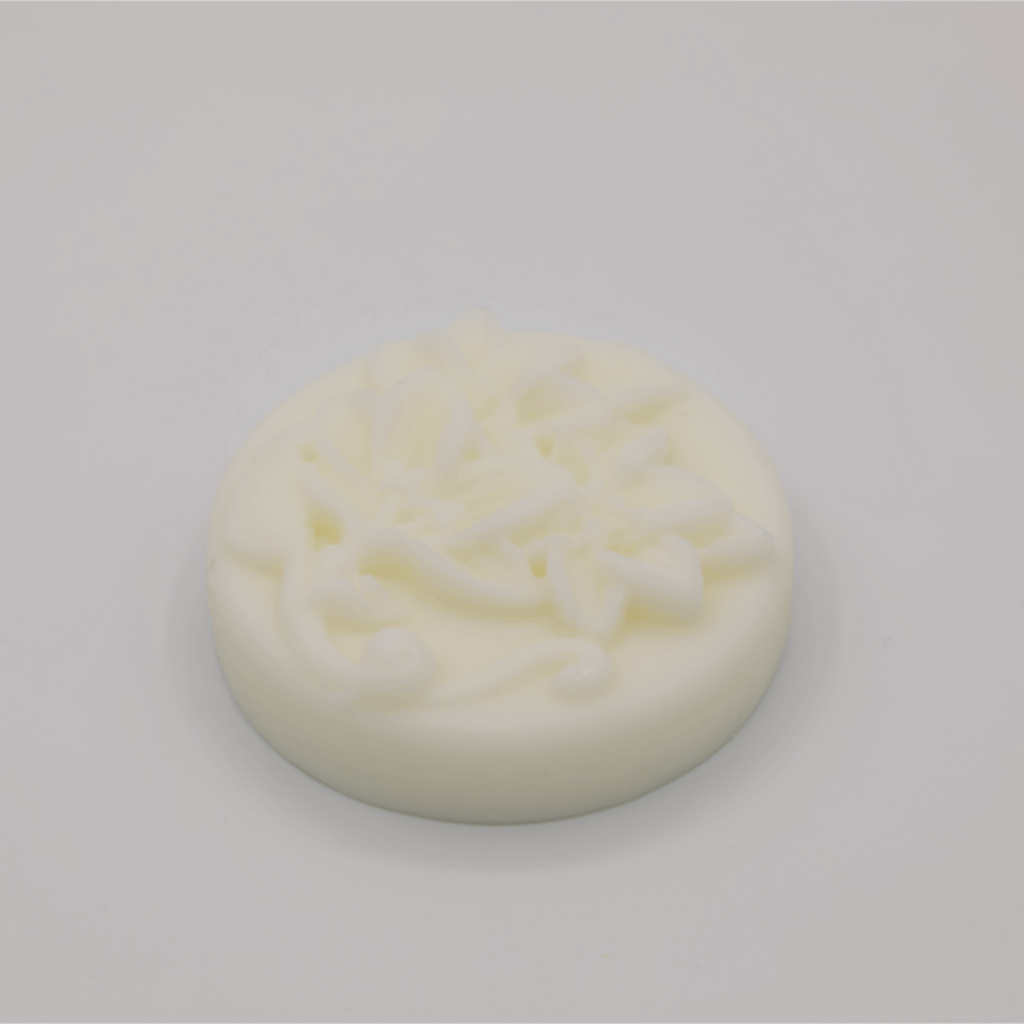 Round white tallow bar with floral decorations on a gray background