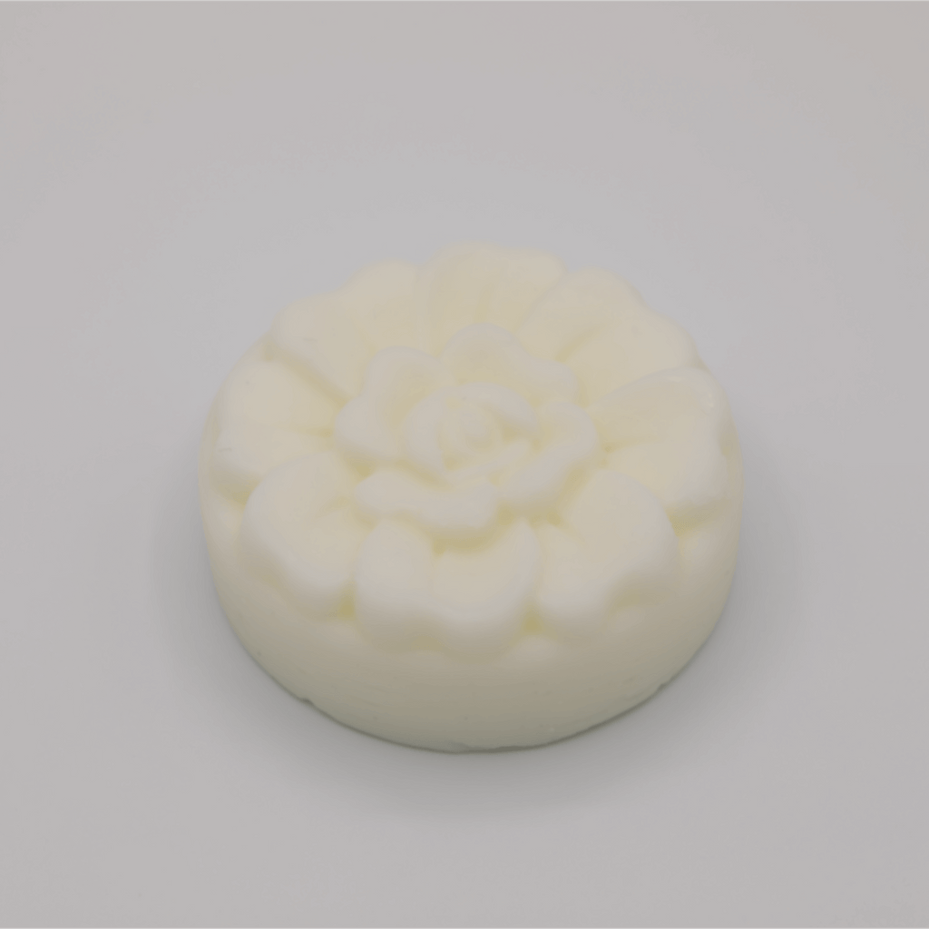 Round white tallow bar with floral pattern on a gray background