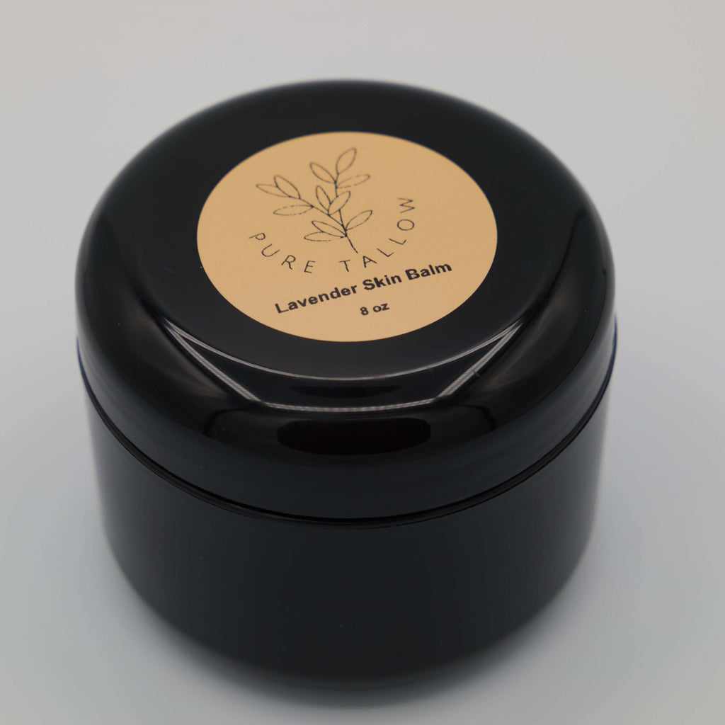 Black container of Pure Tallow Lavender Skin Balm on a light gray background